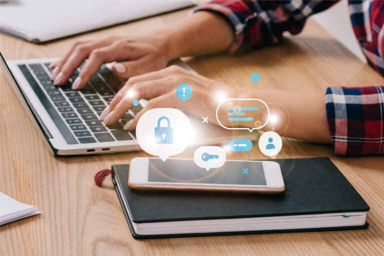 partial view of woman typing on laptop at tabletop with smartphone and notebook cyber security | Applivery